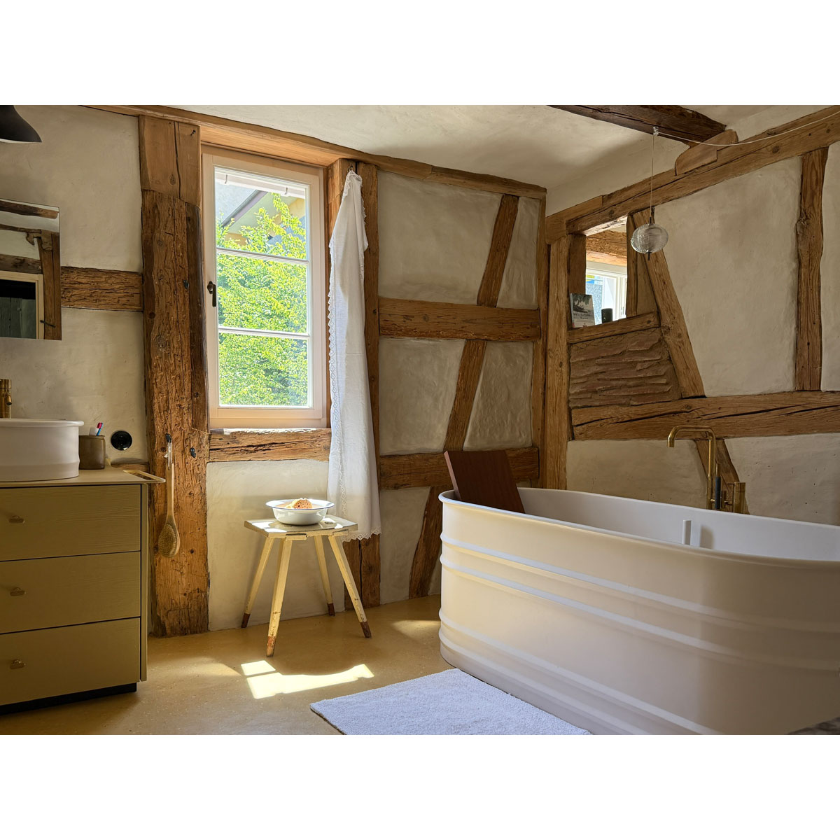 Badewanne vor einer Fachwerkwand