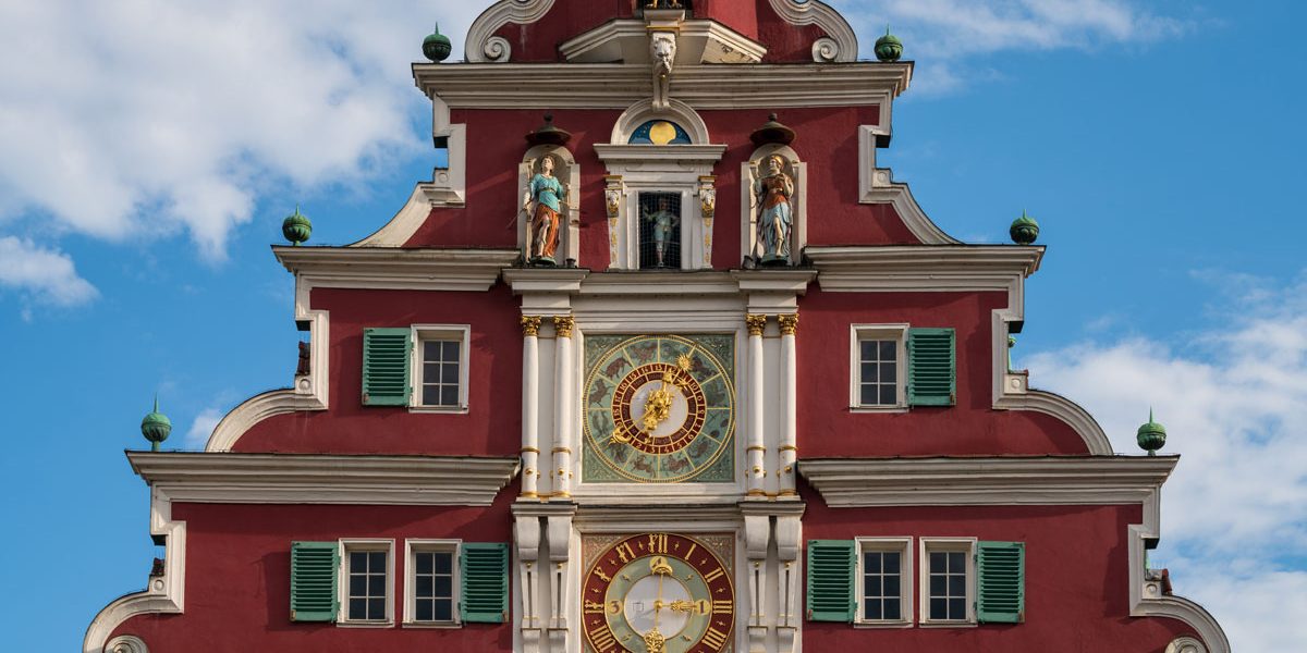 reich geschmückter Giebel eines historischen Gebäudes mit zwei Uhren
