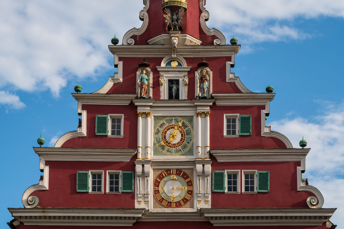 reich geschmückter Giebel eines historischen Gebäudes mit zwei Uhren