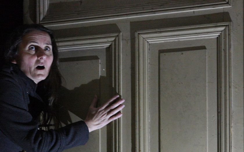 Person mit aufgerissenen Augen an einer Tür