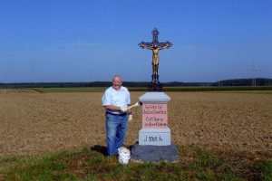 Mann an einem Feldkreuz