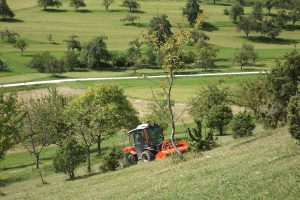 Mähtraktor auf einer steilen Wiese