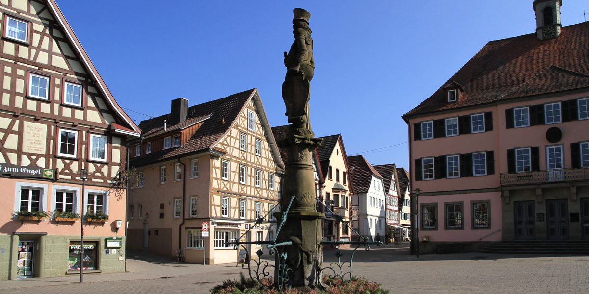 Platz mit alten Gebäuden uind einem Brunnen