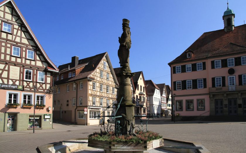 Platz mit alten Gebäuden uind einem Brunnen