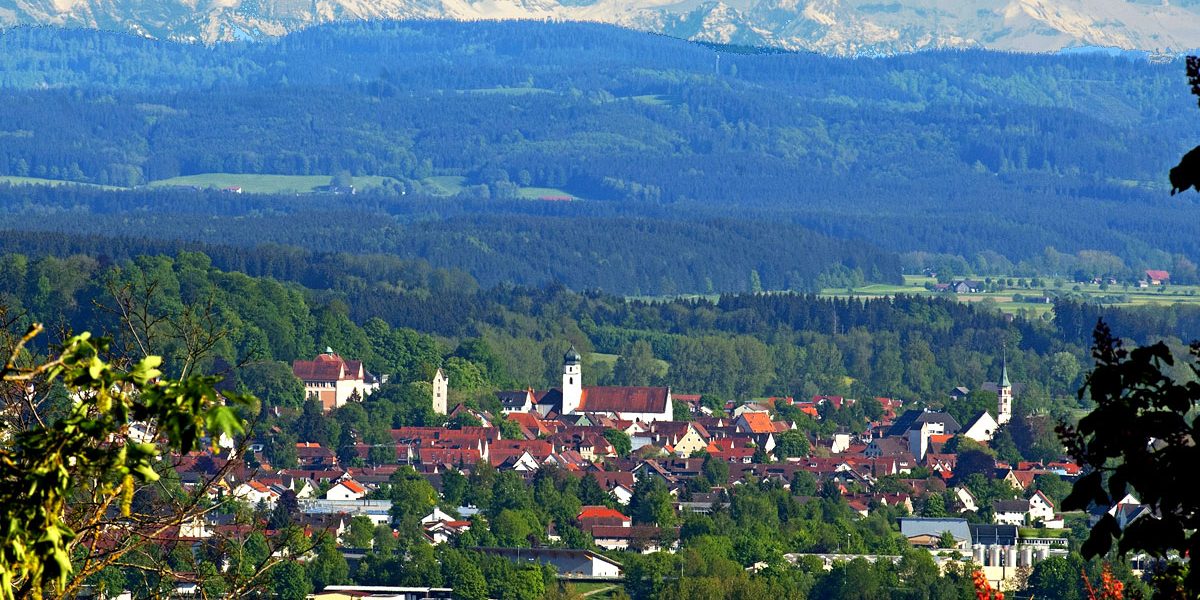 Blick über eine Stadt auf ein Bergpanorama