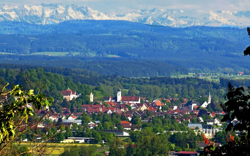 Blick über eine Stadt auf ein Bergpanorama