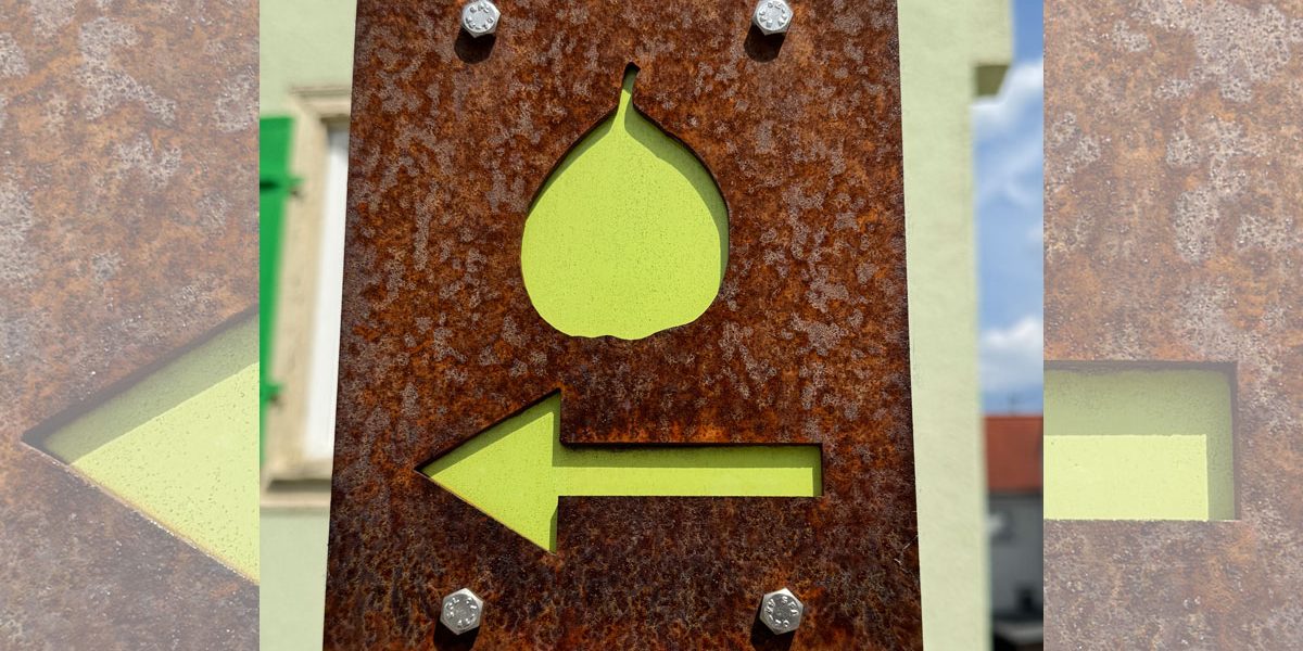 Schild aus Metall mit dem Symbol einer Birne und einem Pfeil
