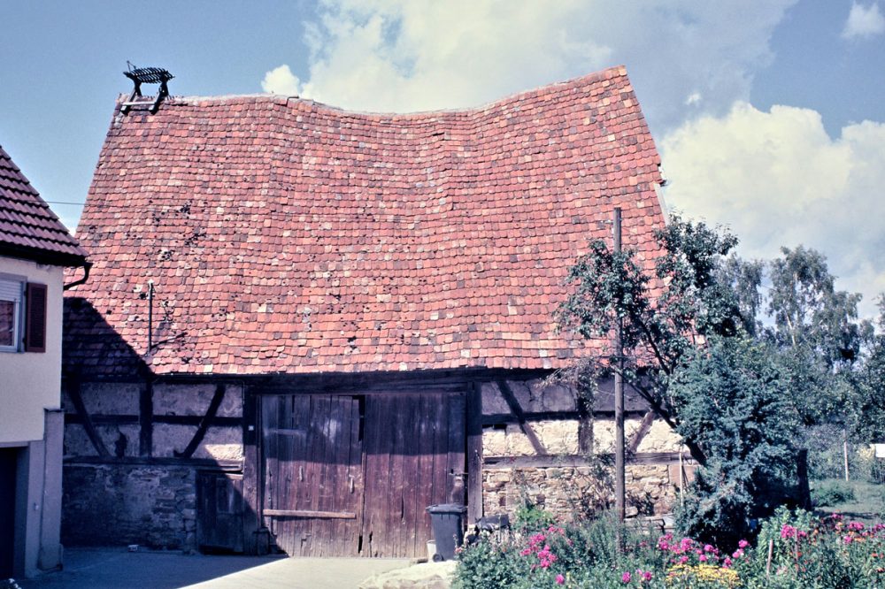 historisches Foto einer Scheune mit beschädigtem Dach