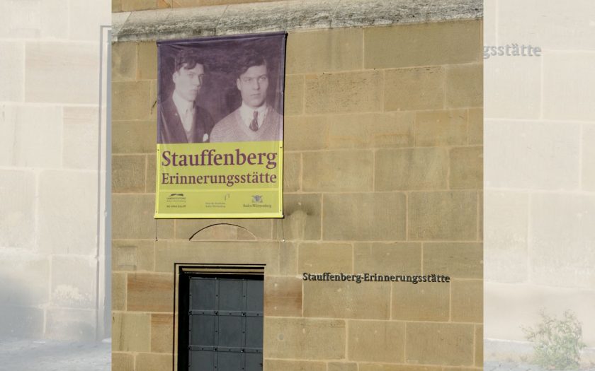 Plakat an einem Gebäude mit Eingangstür aus Metall