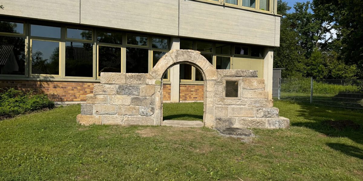 Reste eines Gebäudes in Form eines Sandsteinbogens, der einst ein Hauseingang war